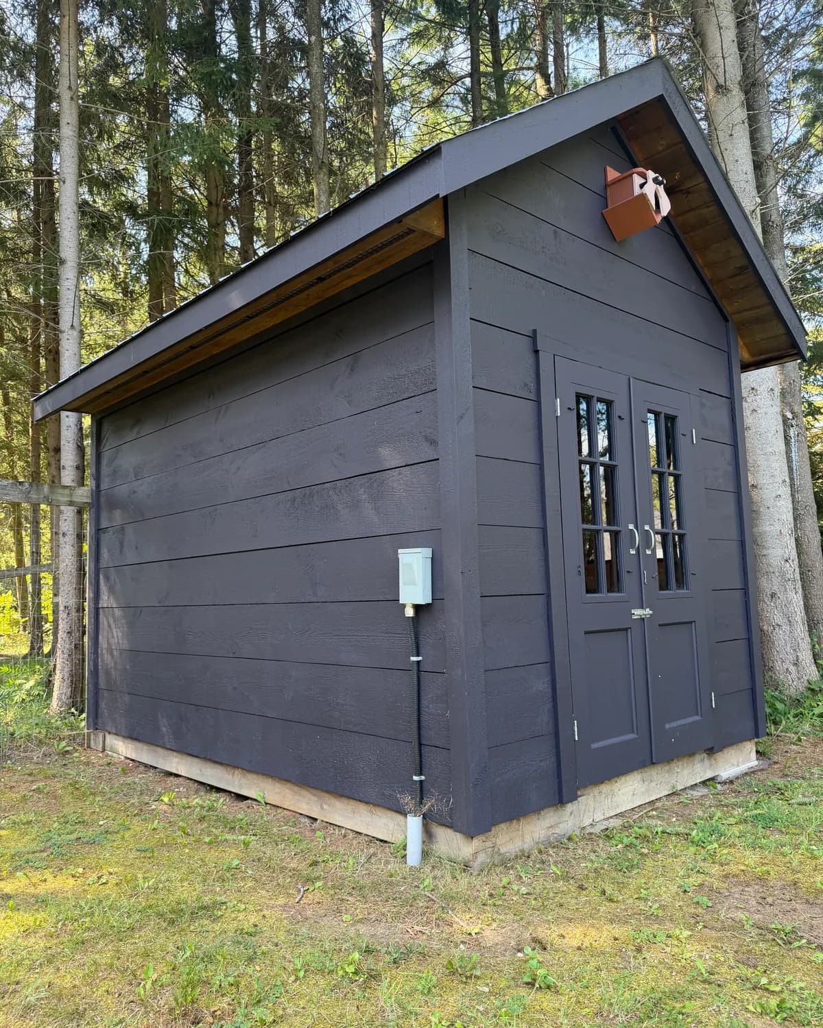An outbuilding on a Nottawa property stained the same deep colour as the house, so the whole property reads as one place.