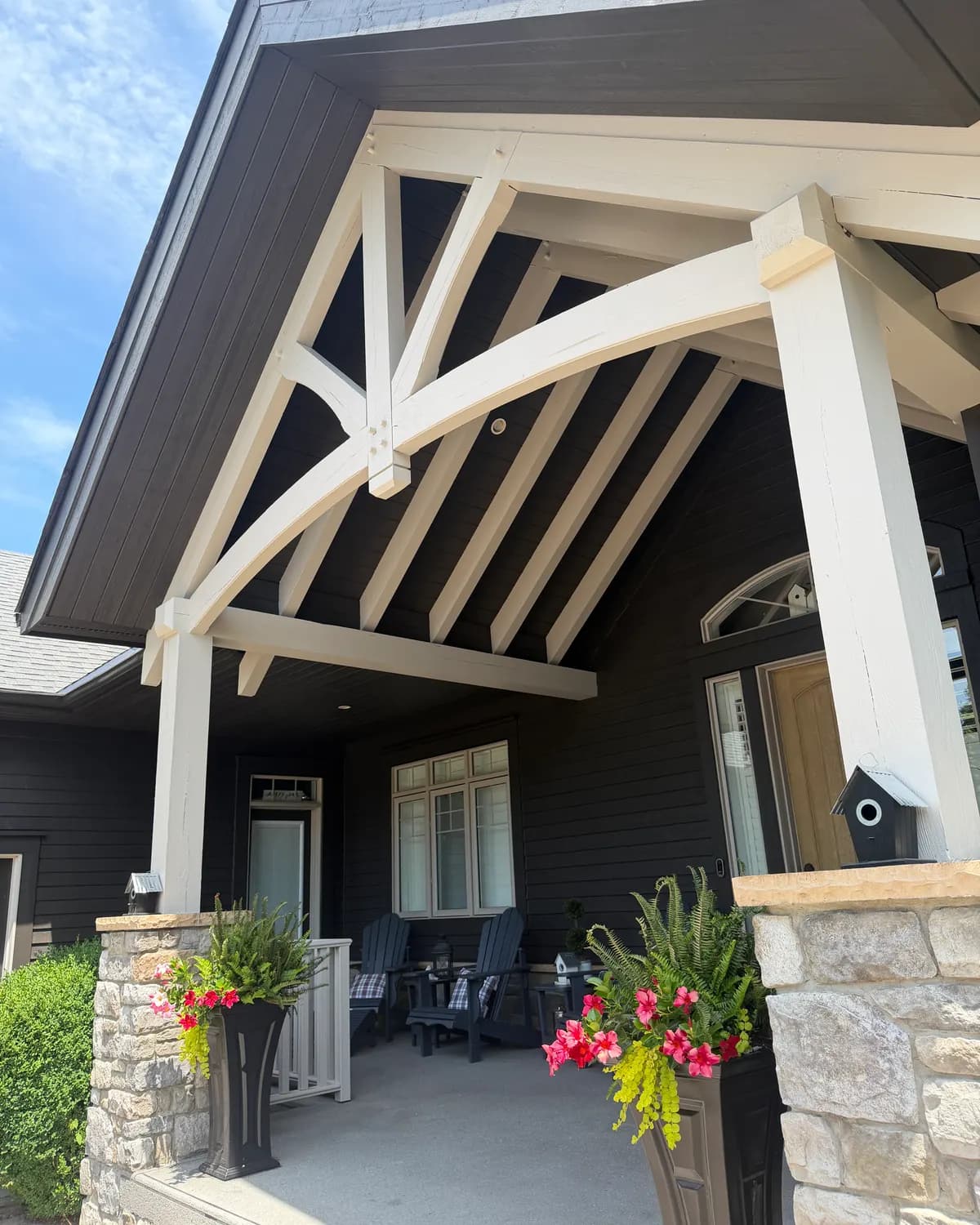 The timber trusses of a Lora Bay entrance in Thornbury, painted white so they stand out against the colour drenched siding behind.
