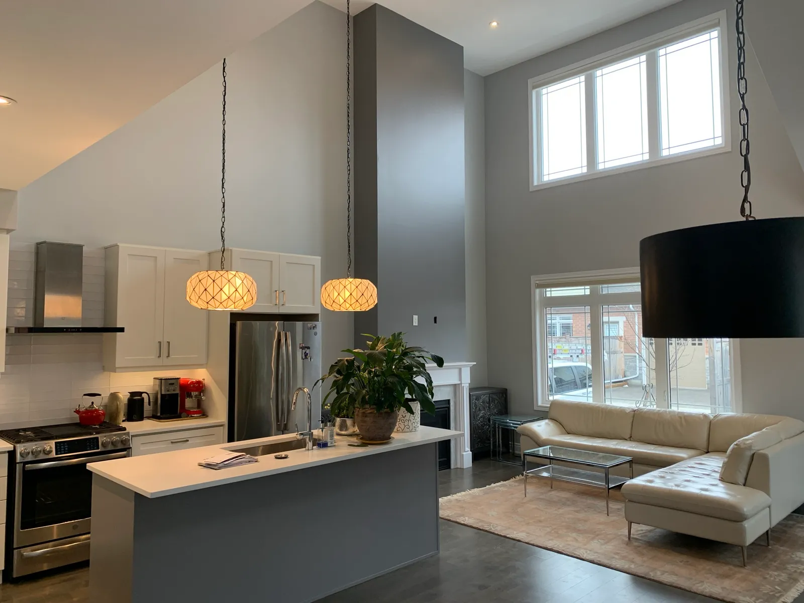 The same great room after painting, the full height feature wall now deep charcoal above the kitchen island.